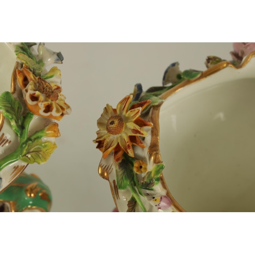 15 - A 19TH CENTURY FLORALLY ENCRUSTED LEAF-HANDLED PEDESTAL VASE with scalloped rim above a gilt embelli... 