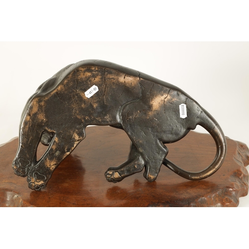 180 - A JAPANESE MEIJI PERIOD PATINATED BRONZE SCULPTURE modelled as a resting tiger on a shaped hardwood ... 