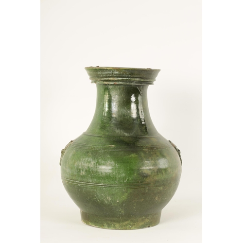 182 - A CHINESE HAN DYNASTY GREEN GLAZED POTTERY HU VASE with masked side mounts and ringed decoration - s... 