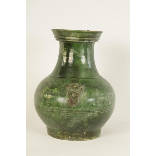 182 - A CHINESE HAN DYNASTY GREEN GLAZED POTTERY HU VASE with masked side mounts and ringed decoration - s... 