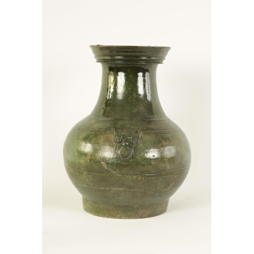 182 - A CHINESE HAN DYNASTY GREEN GLAZED POTTERY HU VASE with masked side mounts and ringed decoration - s... 