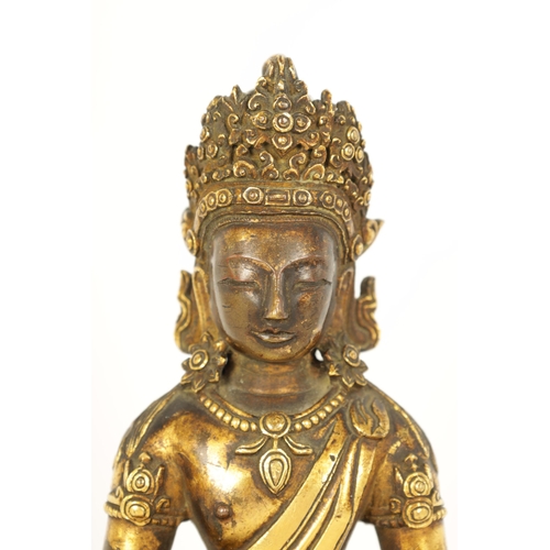 203 - AN EARLY GILT BRONZE TIBETAN BUDDHA DEPICTING AKSHOBHYA seated on a tapered plinth and wood base. (1... 