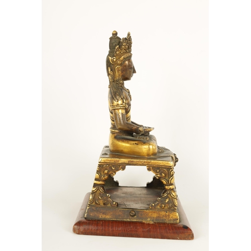 203 - AN EARLY GILT BRONZE TIBETAN BUDDHA DEPICTING AKSHOBHYA seated on a tapered plinth and wood base. (1... 