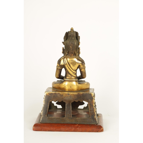 203 - AN EARLY GILT BRONZE TIBETAN BUDDHA DEPICTING AKSHOBHYA seated on a tapered plinth and wood base. (1... 