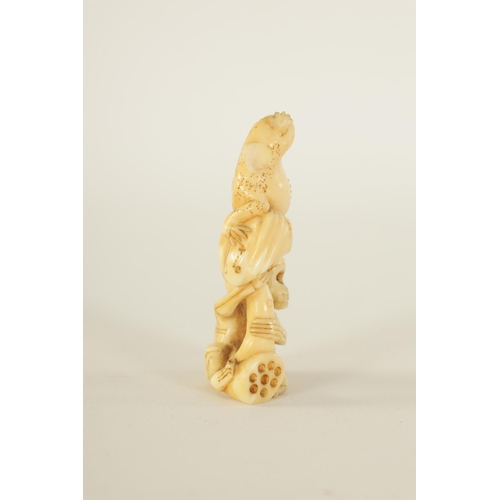 64 - A JAPANESE MEIJI PERIOD CARVED IVORY NETSUKE depicting a frog sat on a skeleton (A.F.). (6.5cm high ... 