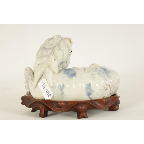 69 - A 19TH CENTURY CHINESE POTTERY WHITE AND BLUE SPASH GLAZED SCULPTURE OF A RECUMBENT HORSE mounted on... 