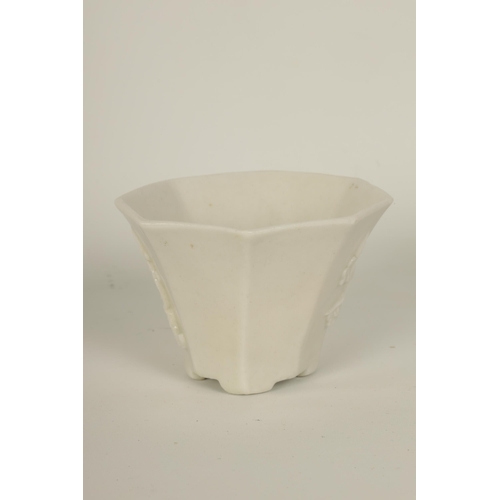 83 - A 19TH CENTURY CHINESE BLANC DE CHINE SMALL VASE of angled tapering form with relief moulded floweri... 