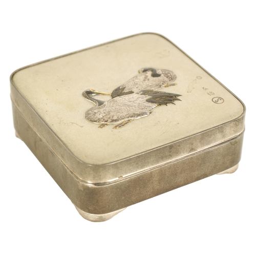 213 - A JAPANESE MEIJI PERIOD SILVER LIDDED BOX decorated with a pair of relief work resting storks - sign... 