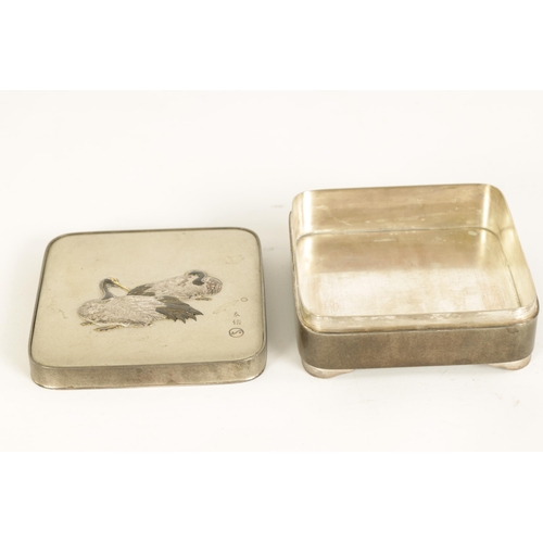 213 - A JAPANESE MEIJI PERIOD SILVER LIDDED BOX decorated with a pair of relief work resting storks - sign... 