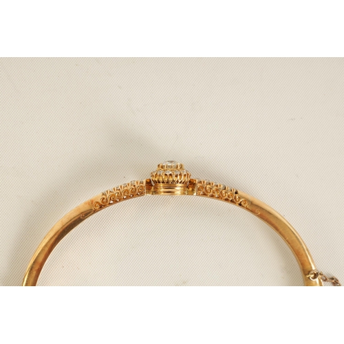 240 - AN 18CT GOLD AND DIAMOND SET LADIES BANGLE with raised centre flower head setting and tapered set sh... 