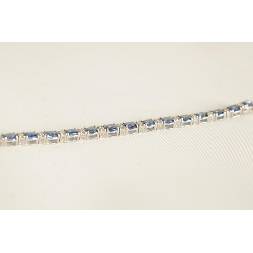 246 - A LADIES 18CT WHITE GOLD DIAMOND AND SAPPHIRE TENNIS BRACELET set with 26 oval-cut sapphires, each l... 