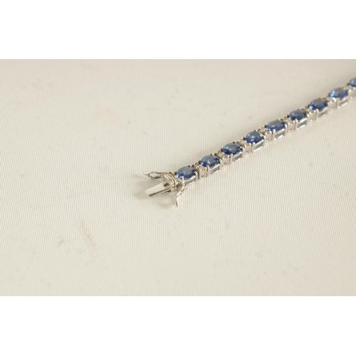 246 - A LADIES 18CT WHITE GOLD DIAMOND AND SAPPHIRE TENNIS BRACELET set with 26 oval-cut sapphires, each l... 