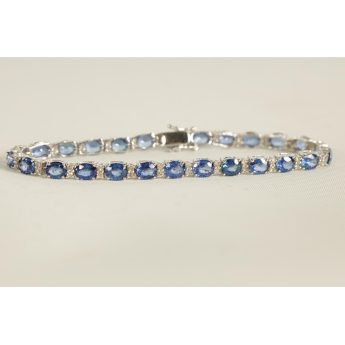 246 - A LADIES 18CT WHITE GOLD DIAMOND AND SAPPHIRE TENNIS BRACELET set with 26 oval-cut sapphires, each l... 