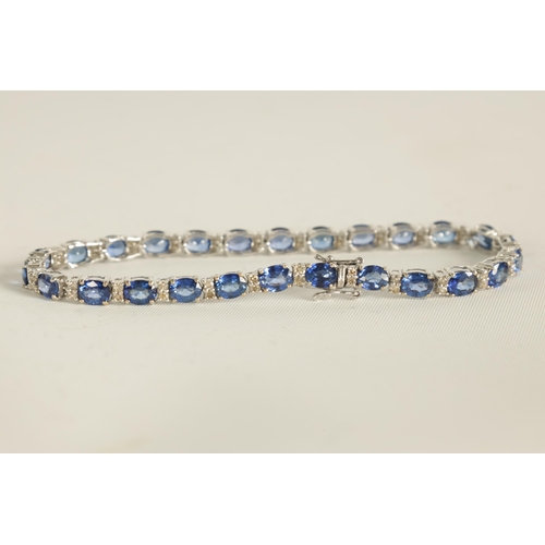 246 - A LADIES 18CT WHITE GOLD DIAMOND AND SAPPHIRE TENNIS BRACELET set with 26 oval-cut sapphires, each l... 