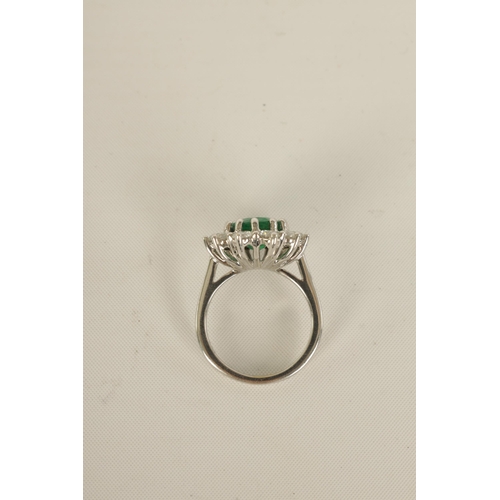 253 - A LARGE 18CT WHITE GOLD EMERALD AND DIAMOND RING set with a 3.31ct oval emerald surrounded by 11 bri... 