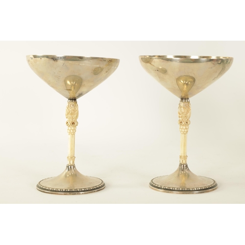 292 - A PAIR OF EARLY 20TH CENTURY SILVER AND CARVED IVORY CHALICES BY M.T. WETZLAR with tapering bowls ab... 