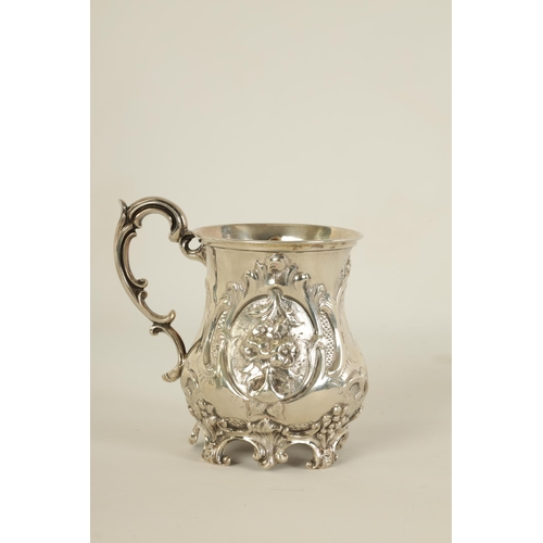 293 - A VICTORIAN SILVER BALUSTER MUG of ornate embossed rococo design with scroll handle and feet - Londo... 