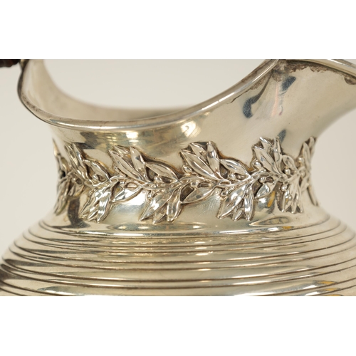 296 - AN EDWARD VII SILVER JUG of squat baluster form with ribbed body, leaf and berry design below the sp... 