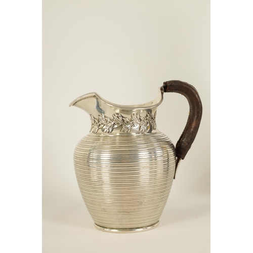 296 - AN EDWARD VII SILVER JUG of squat baluster form with ribbed body, leaf and berry design below the sp... 