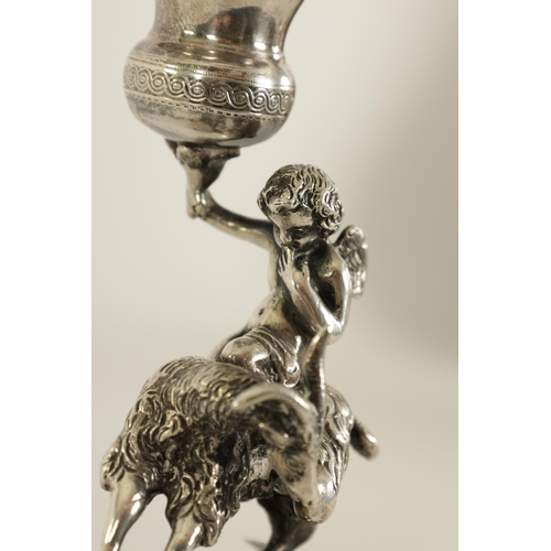 299 - A 19TH CENTURY CONTINENTAL SILVER FIGURAL CANDLESTICK modelled as Cupid riding a goat holding an eng... 