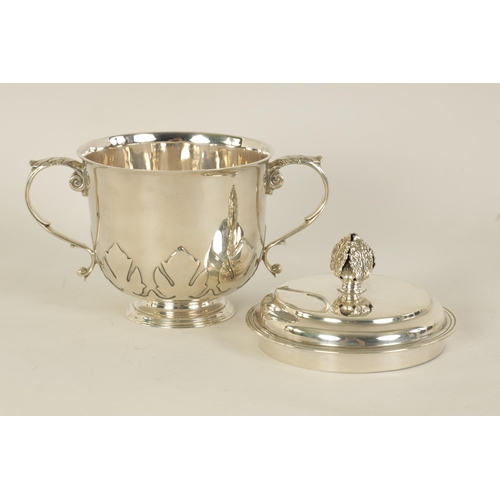 306 - A GEORGE V SILVER PORRINGER the lift-off lid with leaf cast finial above a shaped body with fleur-de... 