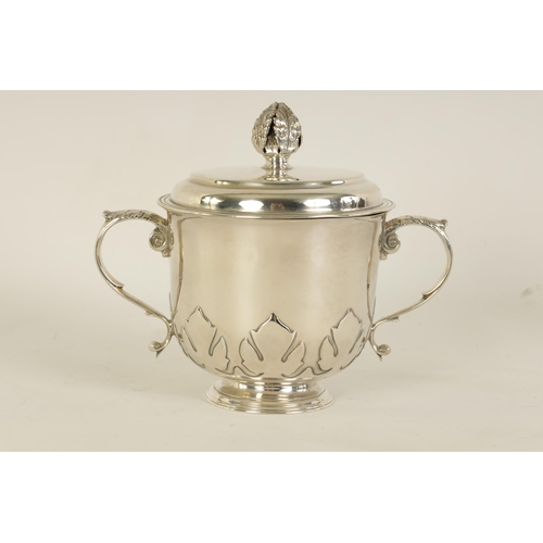 306 - A GEORGE V SILVER PORRINGER the lift-off lid with leaf cast finial above a shaped body with fleur-de... 