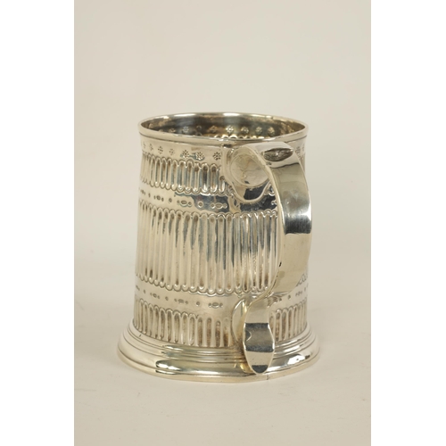 307 - AN EARLY GEORGIAN SILVER MUG the tapered body with fluted and punched decoration, shaped side handle... 