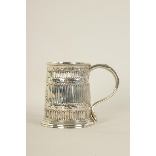 307 - AN EARLY GEORGIAN SILVER MUG the tapered body with fluted and punched decoration, shaped side handle... 