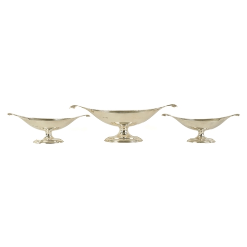 311 - A GRADUATED SET OF THREE EDWARD VII OVAL SILVER DESSERT DISHES with shell-shaped side handles standi... 