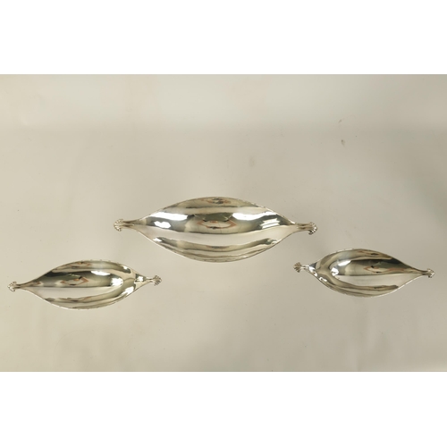 311 - A GRADUATED SET OF THREE EDWARD VII OVAL SILVER DESSERT DISHES with shell-shaped side handles standi... 