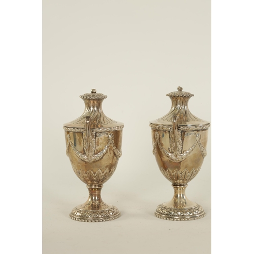 313 - A PAIR OF EDWARD VII ‘ADAM STYLE’ SILVER TEA CADDIES the urn shaped bodies with leafwork handles and... 