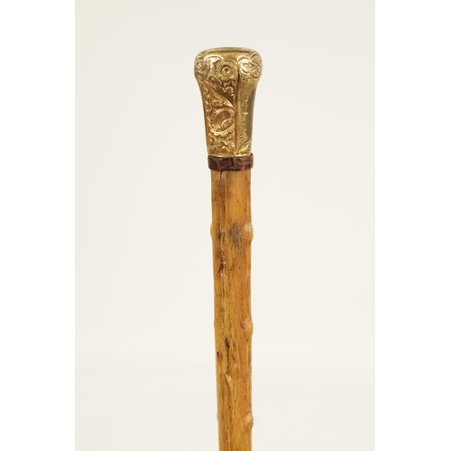 372 - A 19TH CENTURY RHINOCEROS HORN WALKING STICK with gilt metal embossed handle and branch effect taper... 