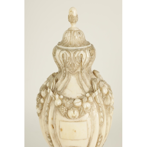 501 - A 18TH/19TH CENTURY FRENCH CARVED IVORY URN FINIAL of shaped reeded form with acorn finial and finel... 