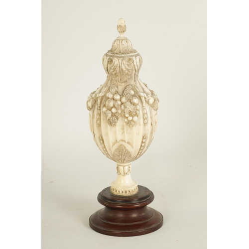 501 - A 18TH/19TH CENTURY FRENCH CARVED IVORY URN FINIAL of shaped reeded form with acorn finial and finel... 