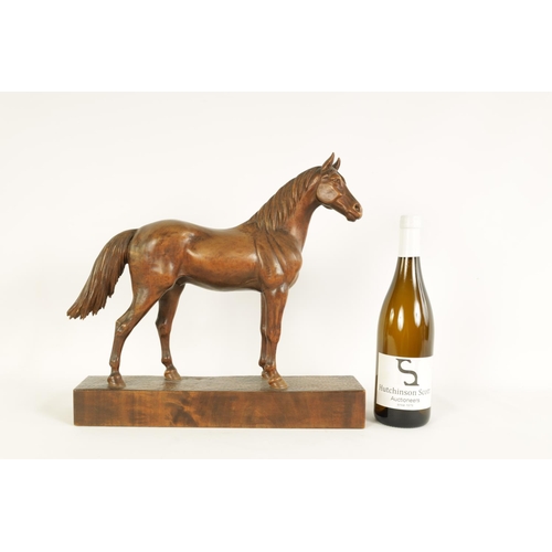 561 - A LATE 19TH CENTURY SWISS CARVED WOOD EQUESTRIAN SCULPTURE depicting a standing horse on plinth base... 