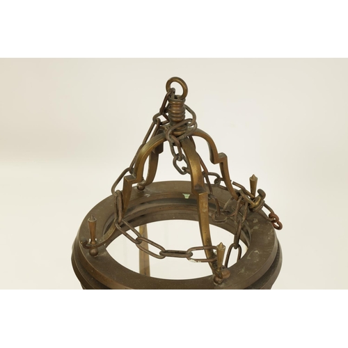 566 - AN UNUSUAL 19TH CENTURY BRASS CIRCULAR HANGING LANTERN of cylindrical glazed panelled form beneath s... 