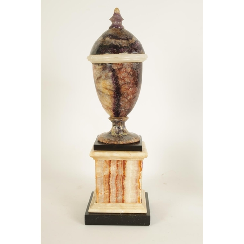 601 - A 19TH CENTURY BLUE JOHN COVERED URN mounted on a square veined agate plinth base (44cm high)