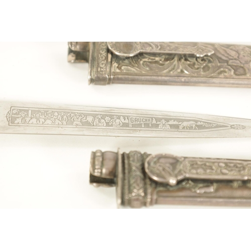 639 - TWO ARGENTINIAN SILVER GAUCHO KNIVES the larger with relief decoration depicting dogs within a carto... 