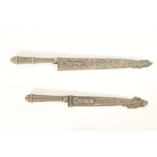 639 - TWO ARGENTINIAN SILVER GAUCHO KNIVES the larger with relief decoration depicting dogs within a carto... 