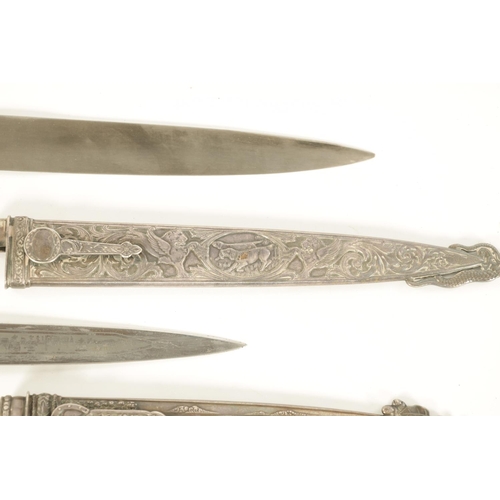 639 - TWO ARGENTINIAN SILVER GAUCHO KNIVES the larger with relief decoration depicting dogs within a carto... 