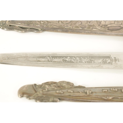 639 - TWO ARGENTINIAN SILVER GAUCHO KNIVES the larger with relief decoration depicting dogs within a carto... 