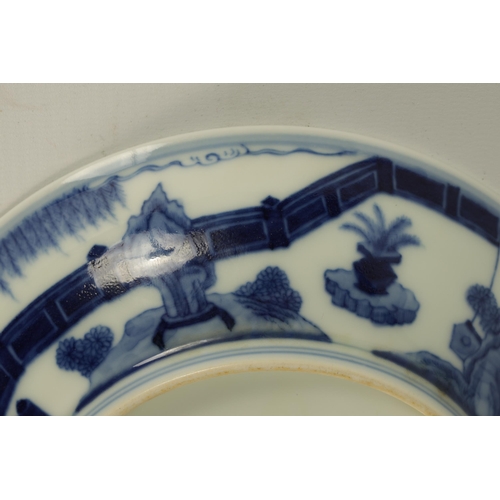 105 - A LATE 19TH CENTURY CHING DYNASTY CHINESE BLUE AND WHITE BOWL decorated with an outer fenced garden ... 