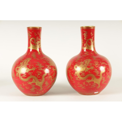 116 - A PAIR OF 19TH CENTURY CHINESE CORAL RED AND GILT DECORATED BOTTLE VASES decorated stylised five-cla... 