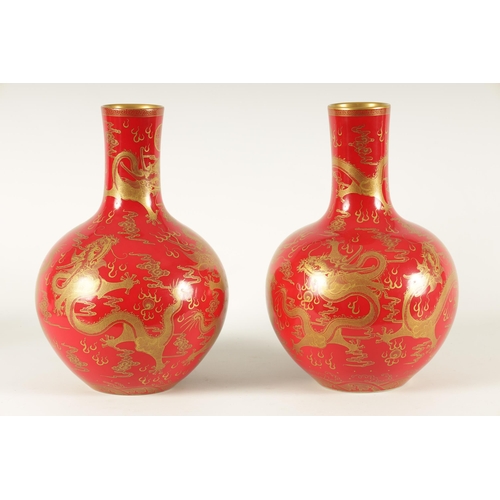 116 - A PAIR OF 19TH CENTURY CHINESE CORAL RED AND GILT DECORATED BOTTLE VASES decorated stylised five-cla... 