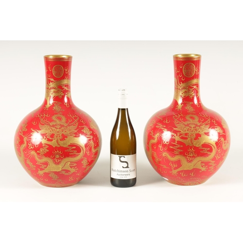 116 - A PAIR OF 19TH CENTURY CHINESE CORAL RED AND GILT DECORATED BOTTLE VASES decorated stylised five-cla... 