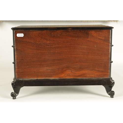 117 - A GOOD 19TH CENTURY ANGLO INDIAN EBONY MINIATURE COMMODE of all-round wavey edge form with moulded d... 