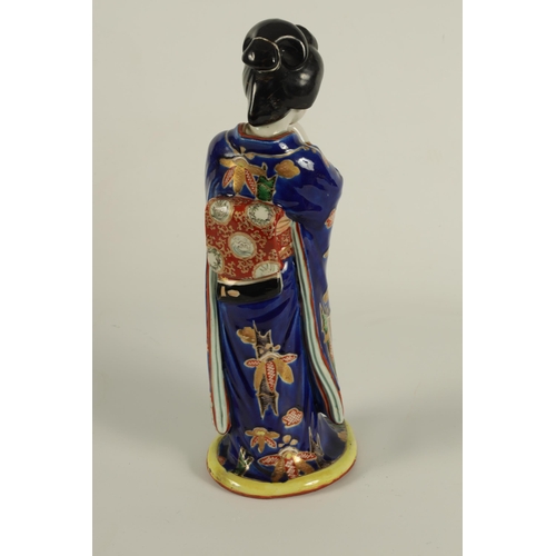 118 - A JAPANESE ARITA STANDING FIGURE OF A GEISHA dressed in finely decorated royal blue costume highligh... 