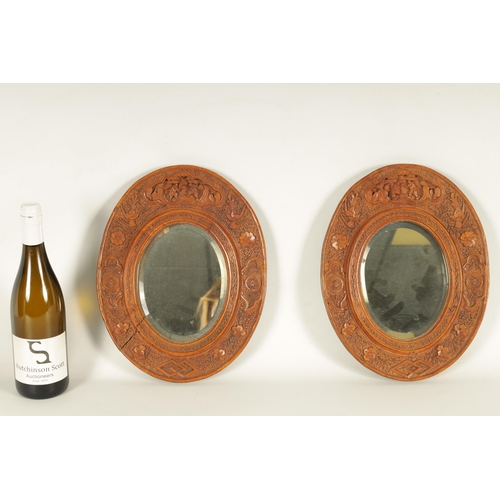 129 - A PAIR OF LATE 19TH CENTURY CHINESE CARVED BOXWOOD OVAL MIRRORS the relief carved frames decorated w... 