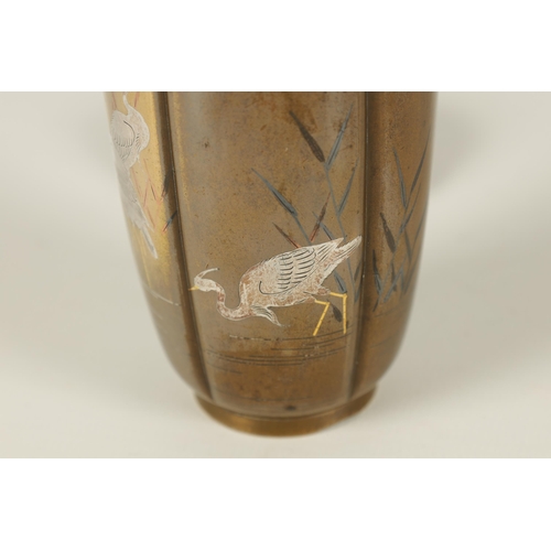 132 - A JAPANESE MEIJI PERIOD GOLD AND SILVER INLAID BRONZE VASE the segmented body depicting wading egret... 