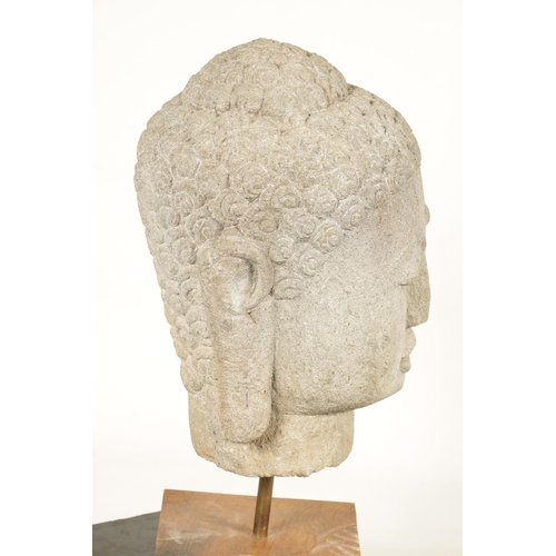 139 - A LARGE CARVED STONE TIBETAN BUDDHIST HEAD mounted on later oak stand (69cm high)